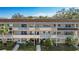 Three-story condo building with balconies, mature trees, and well-maintained landscaping at 2041 Australia W Way # 35, Clearwater, FL 33763