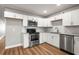 Bright kitchen features white cabinets, stainless steel appliances, granite counters, and wood-look flooring at 2041 Australia W Way # 35, Clearwater, FL 33763
