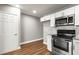 Bright kitchen features white cabinets, stainless steel appliances, granite counters, and wood-look flooring at 2041 Australia W Way # 35, Clearwater, FL 33763