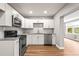 Bright kitchen features white cabinets, stainless steel appliances, granite counters, and wood-look flooring at 2041 Australia W Way # 35, Clearwater, FL 33763