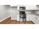Bright kitchen features white cabinets, stainless steel appliances, granite counters, and wood-look flooring at 2041 Australia W Way # 35, Clearwater, FL 33763