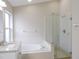 Bright bathroom features double sink vanity with granite countertop, soaking tub, and glass-enclosed shower at 3147 Sunwatch Dr, Wesley Chapel, FL 33544