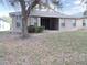 Back of home features a covered patio, complemented by mature trees and natural landscaping at 3147 Sunwatch Dr, Wesley Chapel, FL 33544
