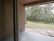 Covered back patio offers a view of lush greenery and natural landscape, with a sliding glass door at 3147 Sunwatch Dr, Wesley Chapel, FL 33544