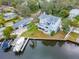 Stunning aerial view of a waterfront home featuring multiple decks and a private boat dock on a sunny day at 320 Georgia Ave, Crystal Beach, FL 34681