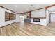 Bright living room featuring light wood floors, a modern fireplace, and seamless flow to the kitchen at 32608 Knollwood Ln, Wesley Chapel, FL 33545