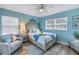 Charming bedroom with coastal decor, blue walls, hardwood floors, ceiling fan, and plenty of natural light at 6537 8Th N Ave, St Petersburg, FL 33710