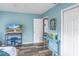 Bright bedroom showcasing coastal decor, cool blue walls, modern tv, and access to the adjoining room at 6537 8Th N Ave, St Petersburg, FL 33710