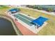 Aerial view of a bocce ball court near a pond, surrounded by walkways and greenery in a serene setting at 6618 Peach Tree Creek Rd, Bradenton, FL 34203