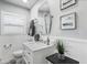 Bright bathroom with marble countertop vanity, stylish mirror and white beadboard at 7984 1St S Ave, St Petersburg, FL 33707