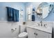 Cozy blue bathroom featuring a white vanity, toilet, and stylish nautical decor at 7984 1St S Ave, St Petersburg, FL 33707