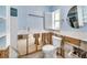 Stylish bathroom with a toilet, round mirror, and a window for natural light at 7984 1St S Ave, St Petersburg, FL 33707
