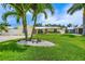 Inviting home with a manicured lawn, palm trees, and a welcoming 'Welcome' sign at 7984 1St S Ave, St Petersburg, FL 33707