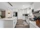 Bright kitchen with shaker cabinets, stainless steel appliances, island with white countertop and dark floors at 7984 1St S Ave, St Petersburg, FL 33707