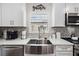 Kitchen features stainless steel appliances, a large sink, mosaic tile backsplash, and eat-in breakfast bar at 7984 1St S Ave, St Petersburg, FL 33707