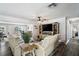 Open living room with comfortable seating, TV, and access to the backyard with water view at 7984 1St S Ave, St Petersburg, FL 33707