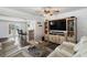 Bright living room with light wood entertainment center, beamed ceiling fan, and bar area overlooking the water at 7984 1St S Ave, St Petersburg, FL 33707