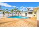Backyard pool area featuring a refreshing pool, brick pavers, and lush palm trees, perfect for relaxation and entertainment at 7984 1St S Ave, St Petersburg, FL 33707