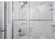 Modern bathroom shower featuring stylish marble-look tile and sleek glass doors at 7984 1St S Ave, St Petersburg, FL 33707