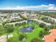 Serene aerial view of condo community with a central pond, lush landscaping, and a swimming pool at 8174 Terrace Garden N Dr # 307, St Petersburg, FL 33709