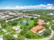 Panoramic aerial view of a residential community with lush landscaping, a pond, and nearby waterways at 8174 Terrace Garden N Dr # 307, St Petersburg, FL 33709