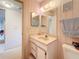 Compact bathroom featuring patterned wallpaper, a single sink vanity with a mirror, and a toilet at 8174 Terrace Garden N Dr # 307, St Petersburg, FL 33709