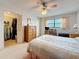Bedroom features a closet, ceiling fan, writing desk and chair, along with neutral carpet at 8174 Terrace Garden N Dr # 307, St Petersburg, FL 33709