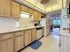 Galley kitchen features light wood cabinets, white appliances, and smooth countertops with an eat-in area at 8174 Terrace Garden N Dr # 307, St Petersburg, FL 33709