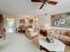 The spacious living room features neutral carpet, comfortable floral patterned furniture, and view into an adjacent dining area at 8174 Terrace Garden N Dr # 307, St Petersburg, FL 33709