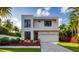 Modern two-story home featuring a neutral palette, dark windows, and vibrant landscaping at 902 W Fribley St, Tampa, FL 33603