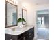 Bathroom featuring a dual sink vanity with granite countertops and large framed mirrors at 9705 Bay Grove Ln, Tampa, FL 33615