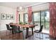 Bright dining area with hardwood floors, a large wooden table, and elegant sheer curtains at 9705 Bay Grove Ln, Tampa, FL 33615