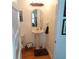 Traditional half-bathroom with pedestal sink, decorative mirror, and hardwood floors at 1001 W Baker St, Plant City, FL 33563
