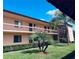 Condo complex featuring a lawn with green landscaping and balconies under a blue sky at 106 Lakeside Ct, Oldsmar, FL 34677