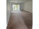 An empty living room with carpet floors and sliding glass doors to a private patio at 106 Lakeside Ct, Oldsmar, FL 34677