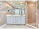 Bright bathroom features double vanity, large mirror and walk-in shower at 11 San Marco St # 807, Clearwater Beach, FL 33767