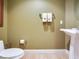 Cozy half bathroom shows toilet, sink and green wall at 11 San Marco St # 807, Clearwater Beach, FL 33767