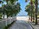 Path to the beach is framed by lush trees and white fencing at 11 San Marco St # 807, Clearwater Beach, FL 33767