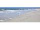Waves gently crash on the shore of a sandy beach, a peaceful view at 11 San Marco St # 807, Clearwater Beach, FL 33767