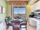Bright dining area with waterfront views from the nearby balcony, and an adjacent office space at 11 San Marco St # 807, Clearwater Beach, FL 33767