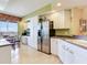 Bright kitchen featuring white cabinets, a stainless steel refrigerator, and an adjacent dining area at 11 San Marco St # 807, Clearwater Beach, FL 33767