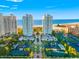 Stunning aerial view of luxurious beachfront condos, tennis courts, and lush green landscaping against a blue sky at 1170 Gulf Blvd # 2001, Clearwater, FL 33767