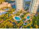 Captivating aerial perspective of condos surrounded by multiple swimming pools, green foliage, and picturesque waterfront scenery at 1170 Gulf Blvd # 2001, Clearwater, FL 33767