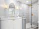 Elegant bathroom with marble vanity, gold fixtures, and glass-enclosed shower featuring a herringbone-patterned tile design at 1170 Gulf Blvd # 2001, Clearwater, FL 33767