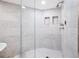 This modern bathroom boasts a glass enclosed shower with marble tile and built in storage at 1170 Gulf Blvd # 2001, Clearwater, FL 33767