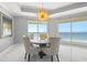 Airy dining room with chandelier and multiple ocean view balcony access points, a perfect entertaining space at 1170 Gulf Blvd # 2001, Clearwater, FL 33767