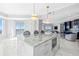 Open kitchen with marble countertops and backsplash, island with seating, luxury appliances and access to outside views at 1170 Gulf Blvd # 2001, Clearwater, FL 33767