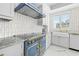 Luxury kitchen showcasing a blue Lacornue range with brass accents, marble countertops and backsplash, and a farmhouse sink at 1170 Gulf Blvd # 2001, Clearwater, FL 33767