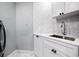 Well-lit laundry room featuring white cabinets, marble countertops, and modern fixtures. There is ample room for storage at 1170 Gulf Blvd # 2001, Clearwater, FL 33767