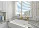 Kitchen sink area features gold fixtures, white cabinets, marble countertops and backsplash, and a view to the outside at 1170 Gulf Blvd # 2001, Clearwater, FL 33767